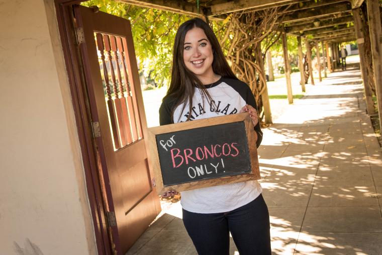 A student holding a slate which has the text Broncos only 