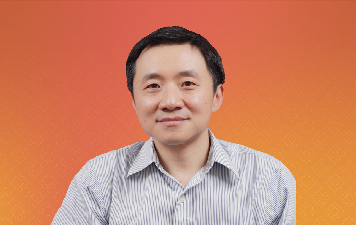 Yi Fang in front of orange backdrop