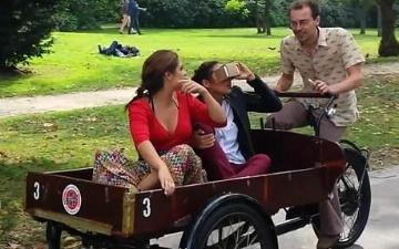 man riding a bike with a cart carrying two children using VR technology.
