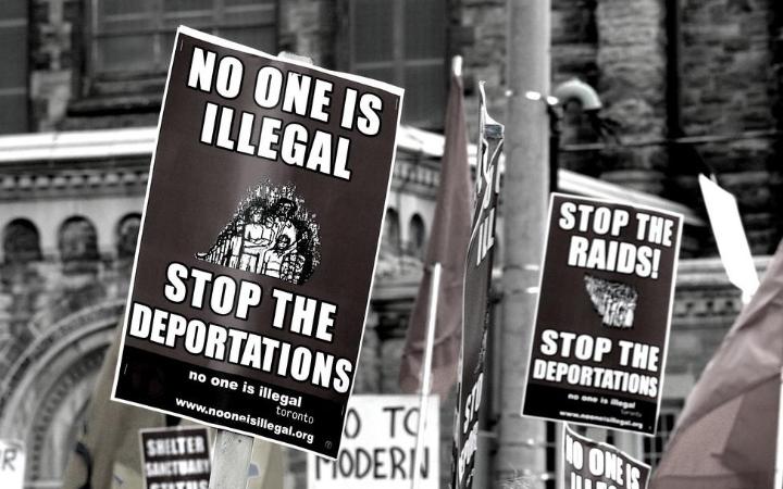 Some posters on the street which has the text No one is illegal stop the deportations