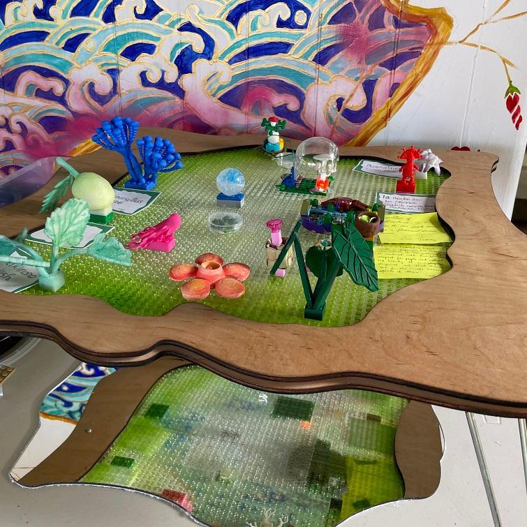 Abstract floating artwork with vibrant colors, mixed materials, and natural elements.
