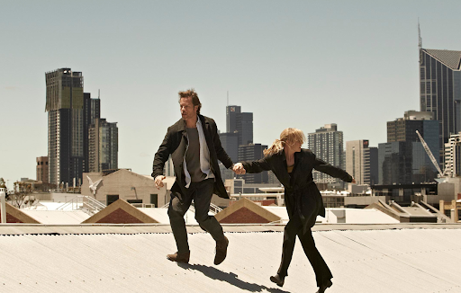 two people running over a rooftop