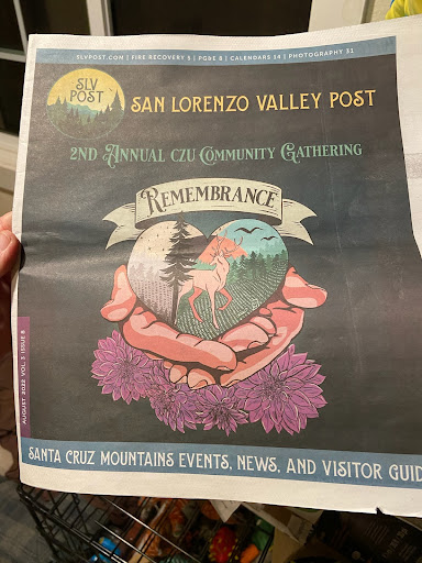 A person holding a newspaper featuring the section titled Happiness - All you need!