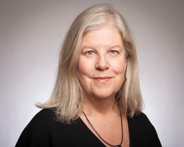 A person wearing a black top, facing the camera.