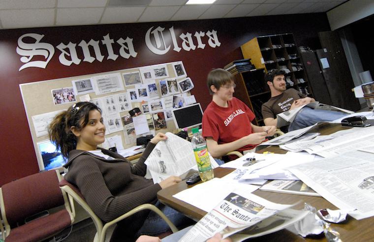 Students working in a media room, with Media Office sign in background.