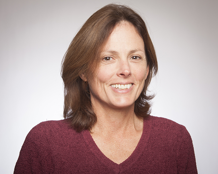 Person smiling in a maroon shirt.
