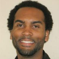 A man smiling in a black shirt, titled Anthony Hazard.