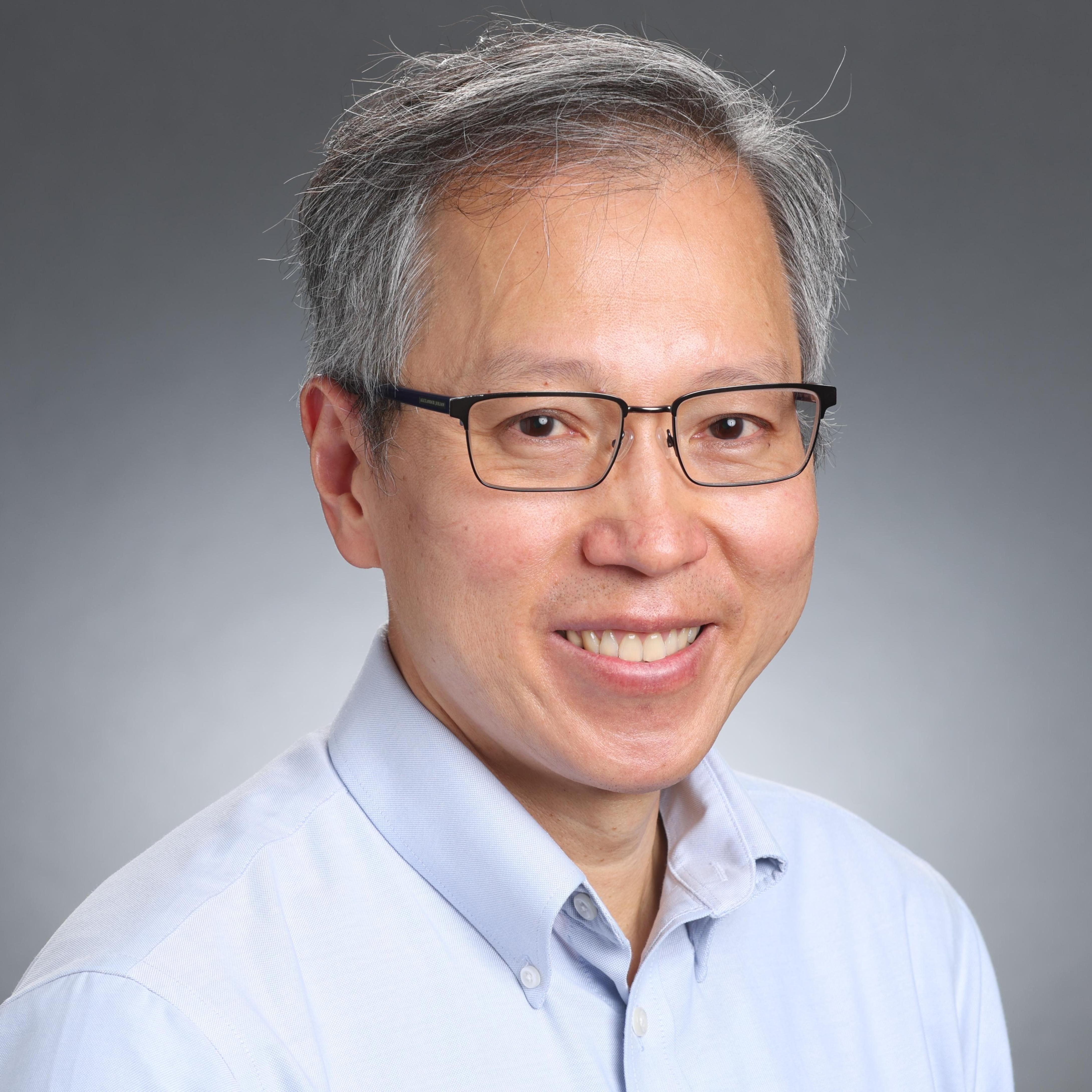 A person wearing glasses and a light blue shirt.