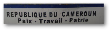 REPUBLIQUE DU CAMEROUN Poste - Travail - Patrie translated to English means REPUBLIC OF CAMEROON Post - Work - Fatherland.
Alt text: Sign with 'REPUBLIQUE DU CAMEROUN' and 'Poste - Travail - Patrie'.
