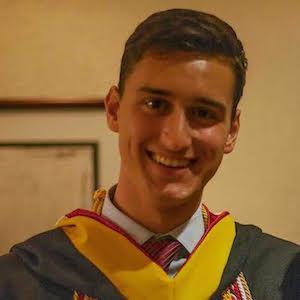 A person named Jesse in graduation attire smiling.