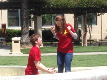 Two people in red shirts talking outdoors.