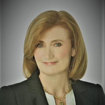 A person in professional attire with a neutral background. image link to story