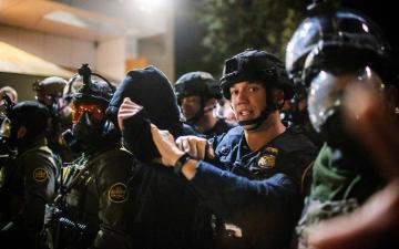A protester is arrested by police and U.S. Border Patrol officers outside a U.S. Immigration and Customs Enforcement facility in Portland, Ore., Monday, Oct. 6, 2025. (AP Photo/Ethan Swope)