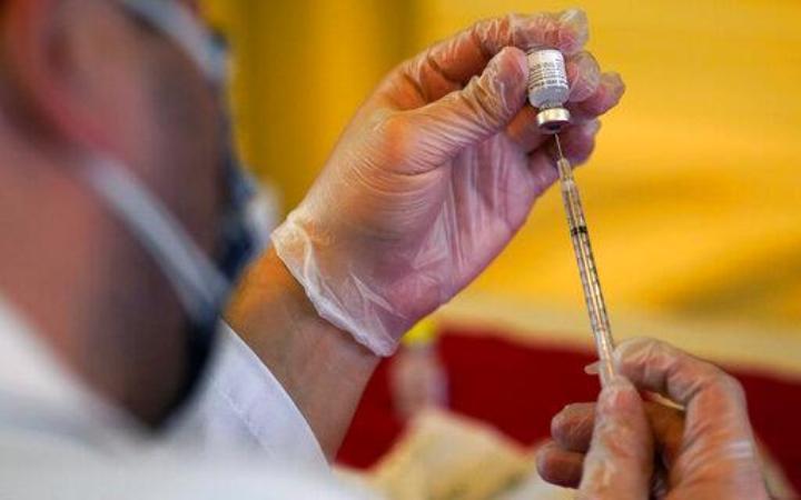 Medical professional holding a syringe and a vile of covid19 vaccine