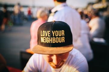 A man wearing a hat that reads Love your Neighbor