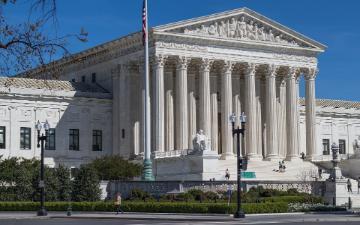 The U.S. Supreme Court Building with a clear blue sky.