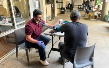 Bilal Arshadullah ’24, Health Equity and Innovation Fellow works with patient at the Opportunity Center Blood Pressure Clinic in Palo Alto, California in May 2025. Photo provided courtesy of Bilal Arshadullah. 
