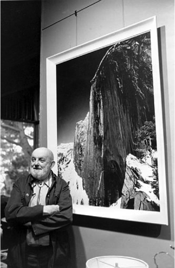Ansel Adams standing in front of his photograph, Monolith: The Face of Half Dome, 1927 