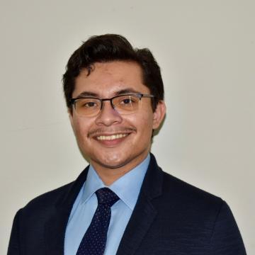 A person in a suit and tie smiling.