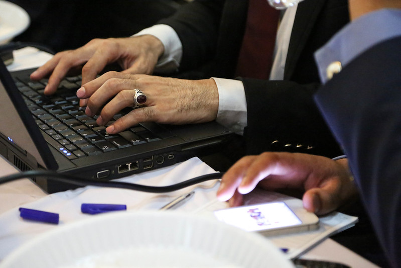 Hands on laptop keyboard and a phone