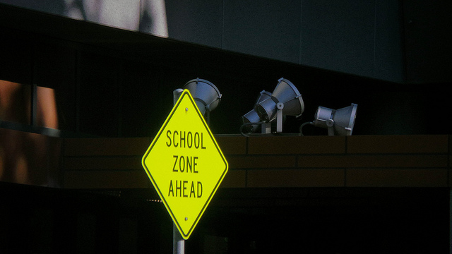 Bright yellow sign with ON AIR on a dark shelf with objects.