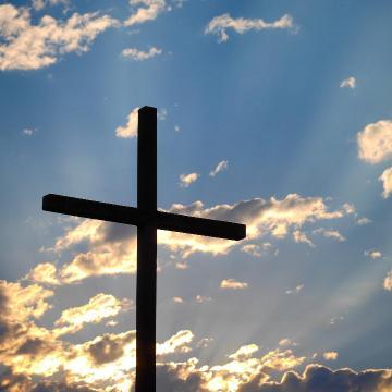 A cross with the sky in the background.