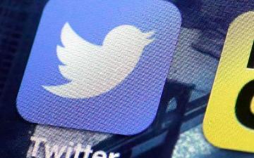 Blue Twitter icon with white bird logo and text on a mobile screen.