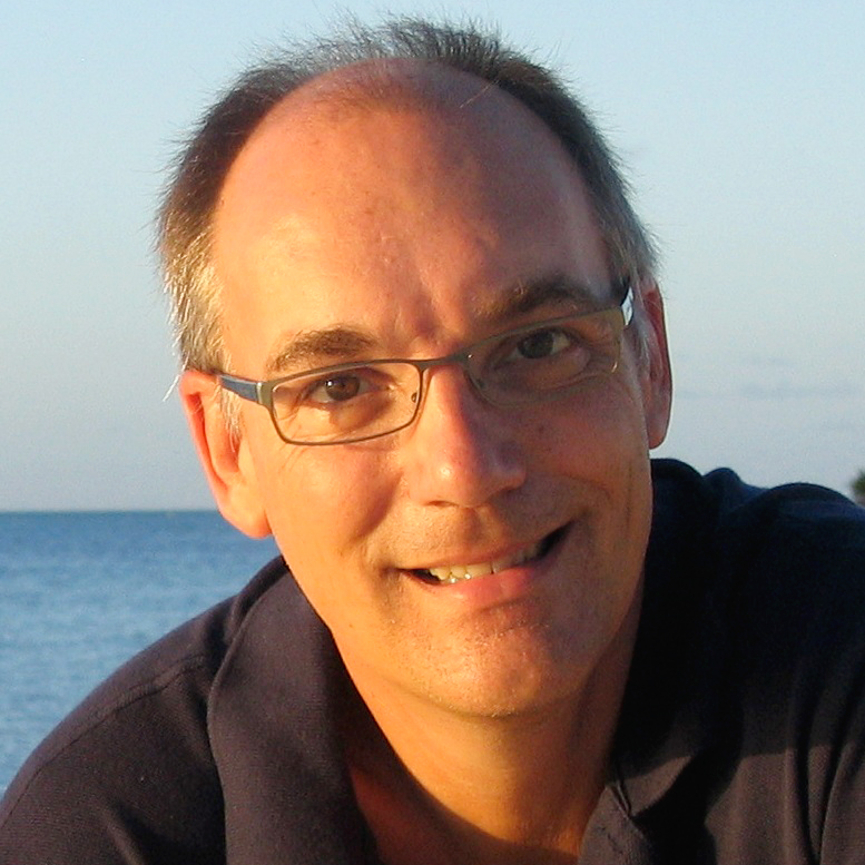 A smiling person by the water.