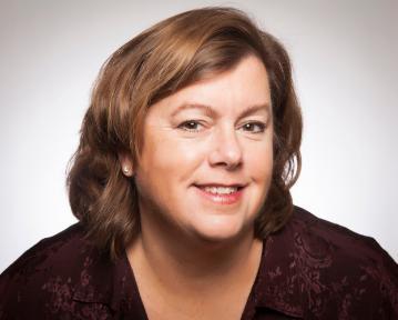 A person smiling in a professional headshot against a white background.