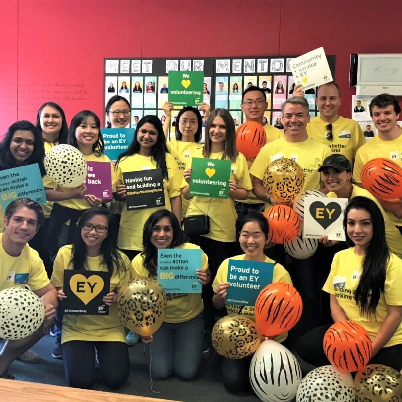 Group of people with balloons at EY Connect Day event, posing for a photo.