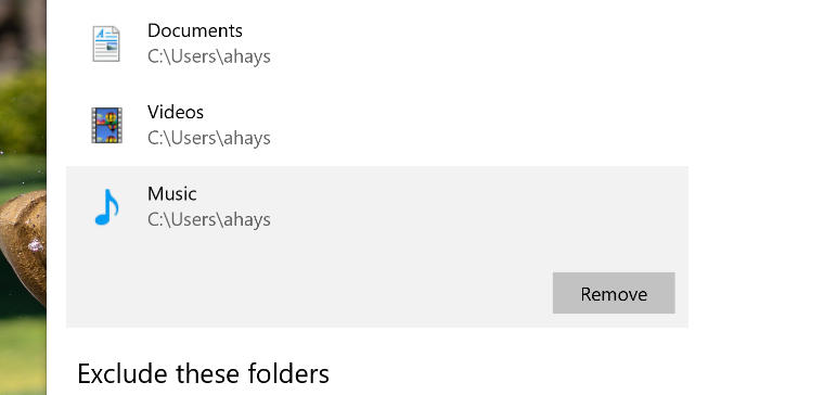 An image of the Windows 10 Backup options page with the Music folder highlighted and a red arrow pointing to the Remove button.