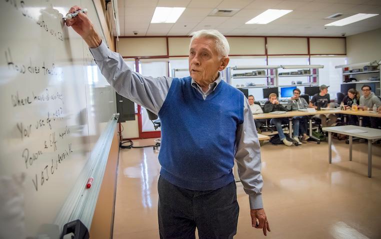 Healy works on equation at the classroom whiteboard.