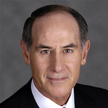A headshot of Larry W. Sonsini in a suit against a grey background.