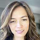 A smiling individual with wavy hair.