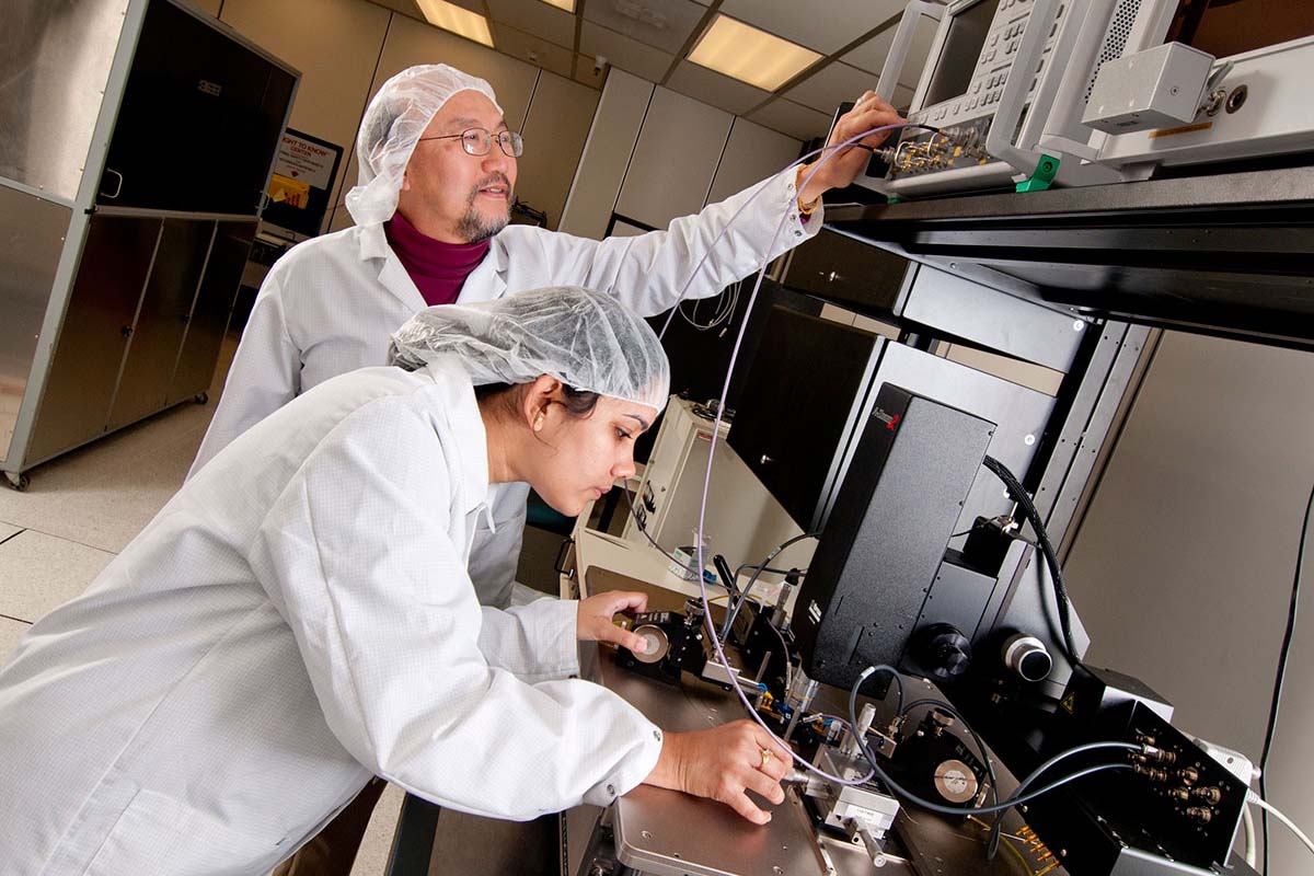 Two researchers in lab working with nanostructure equipment.