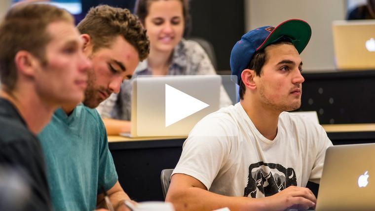 Students in a classroom focused on a presentation or lecture.