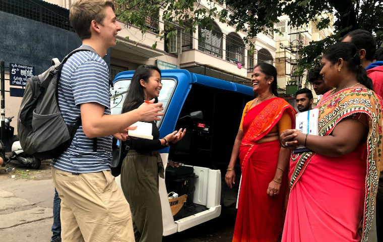 GSBF fellows smiling with women wearing red saris