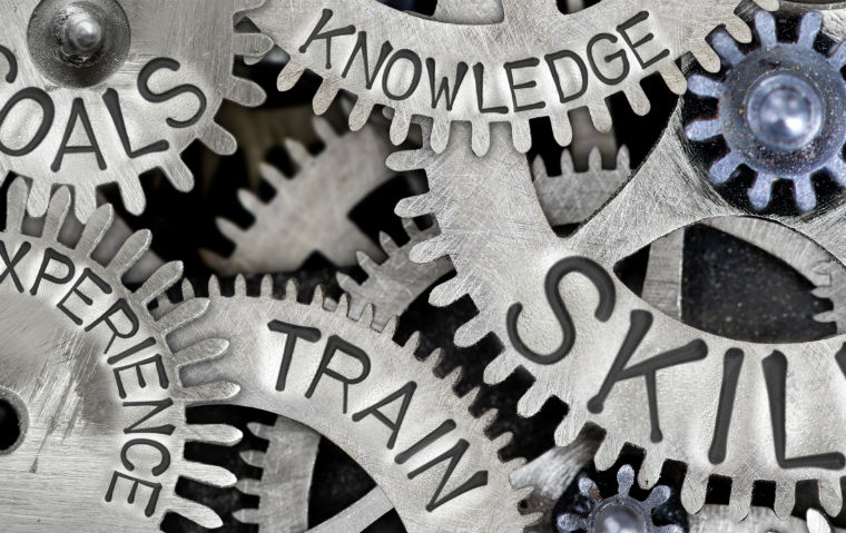 Photo of gears with words like skills and train on them.