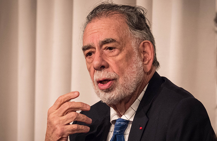 Francis Ford Coppola speaking, wearing a suit and blue tie.