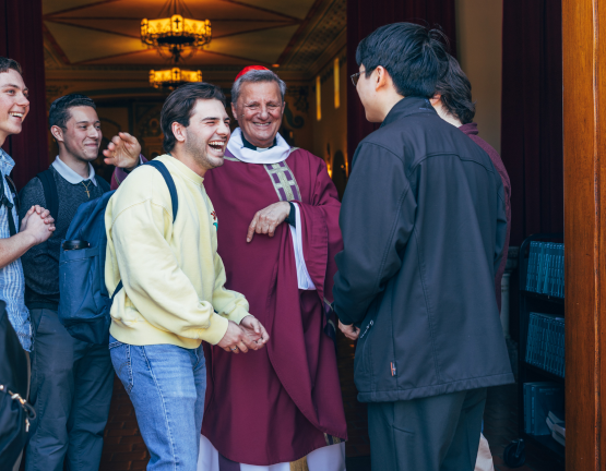 Bishop greeting young people at the door of a church