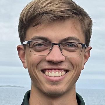 Man with glasses smiling outdoors