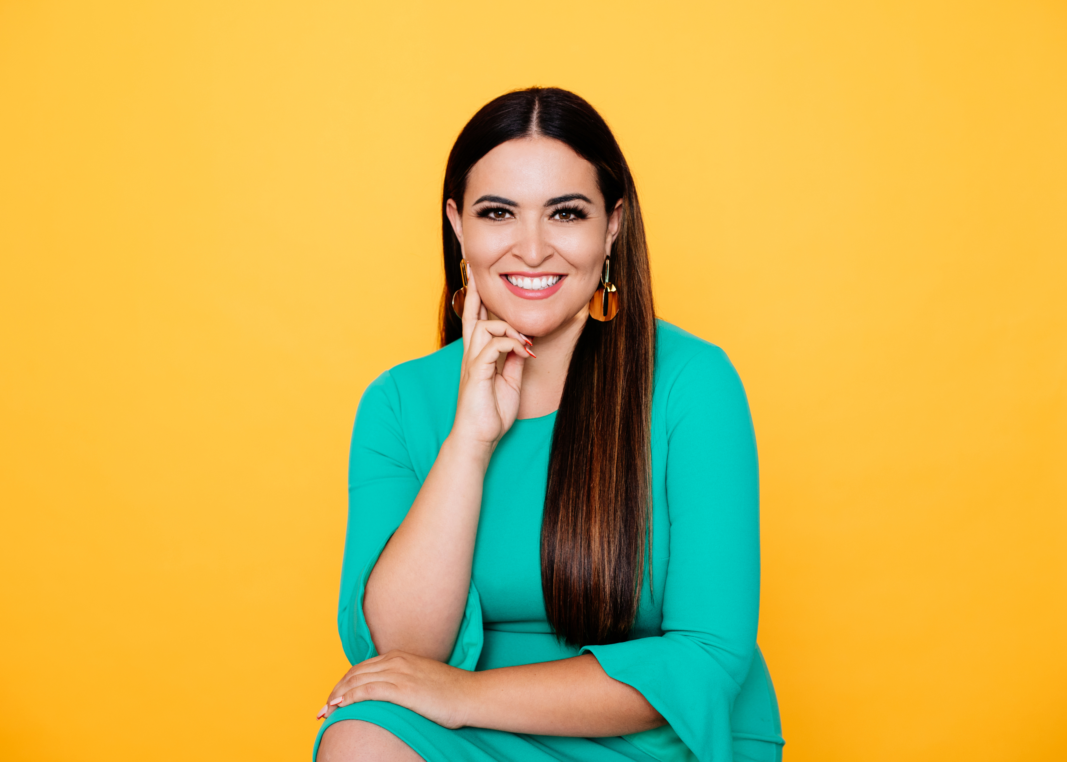 A person in a green top against a yellow background.