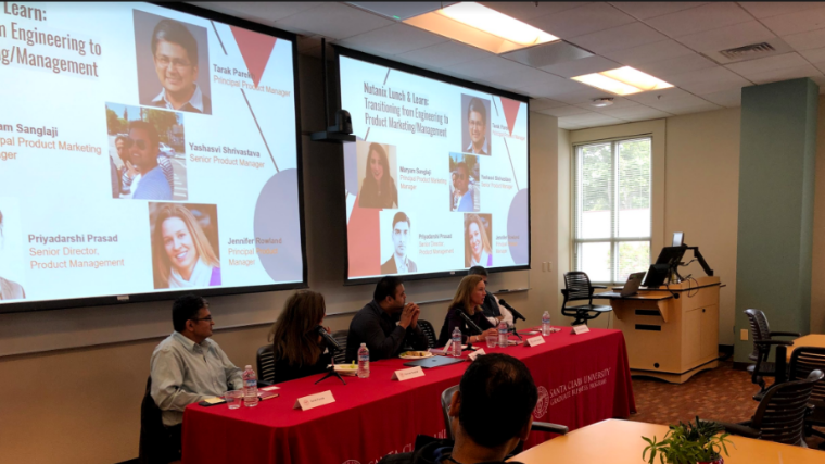 Panelist from the Nutanix Info session seated at table in front of Powerpoint slide back drop.