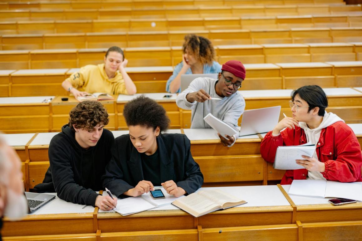 Students seated at wooden desks in tiered seating