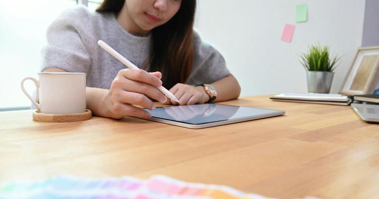 Young creative woman using stylus and tablet