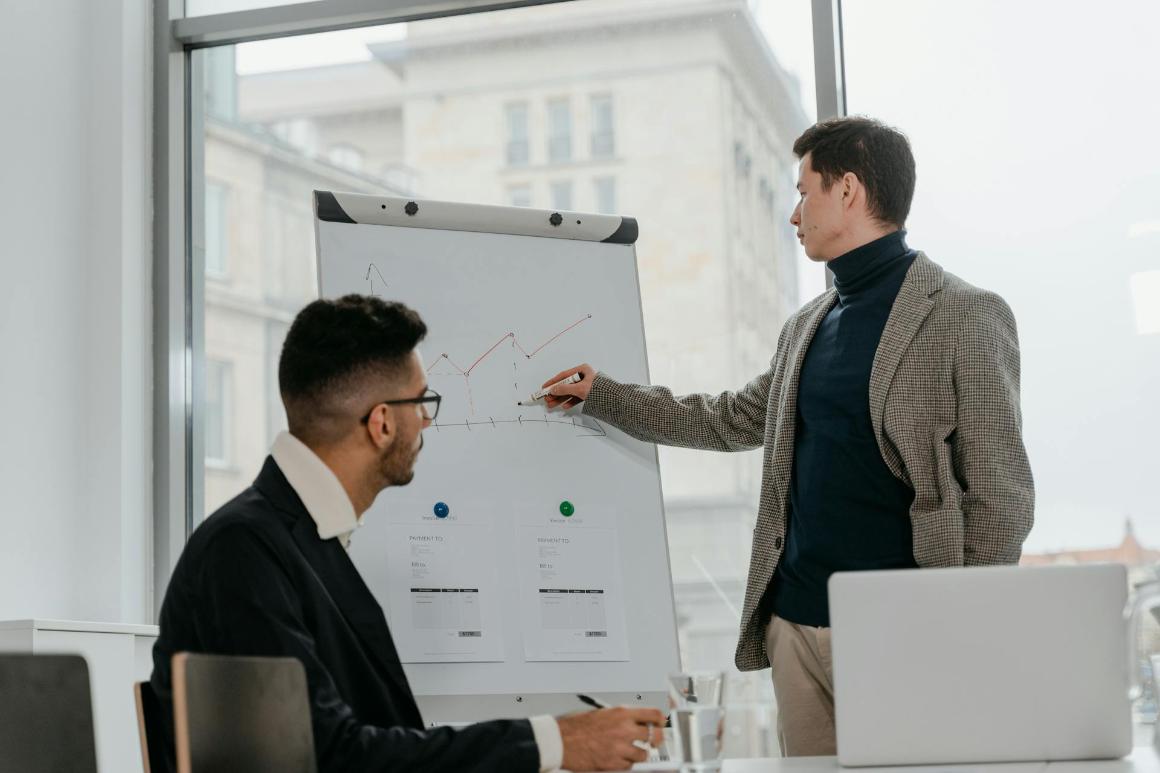 Business professionals discussing findings on a chart printout