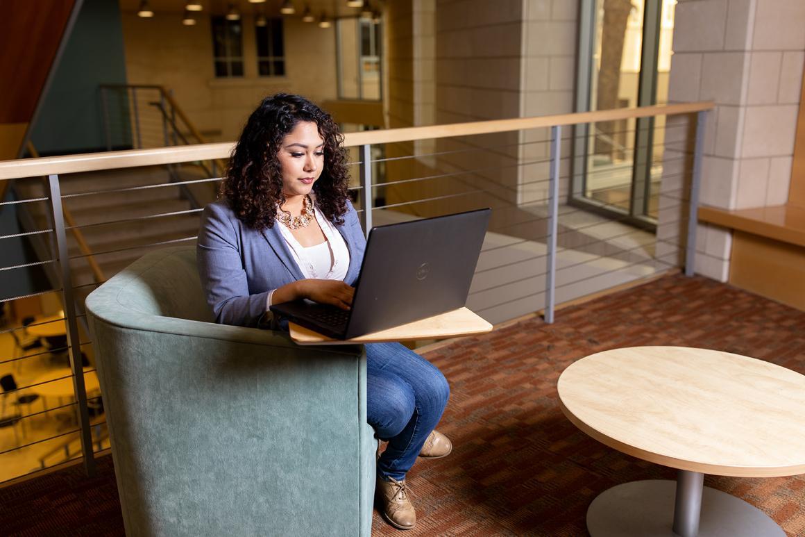 Student with laptop in Lucas Hall second floor common space