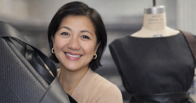 Leavey MS in Marketing alumnae Liz Pham holds one of her luxury leather bags with a mannequin torso in the background