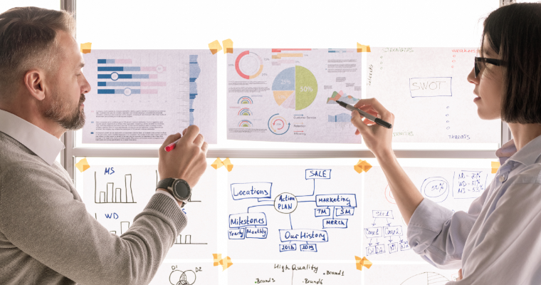 Business professionals discussing graphs taped to window