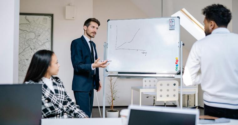 Business professional in suite explaining graph to colleagues